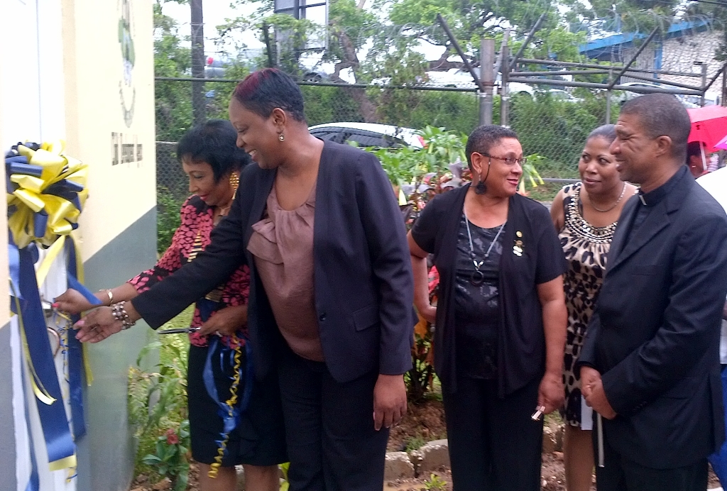 CEO of the Child Development Agency Carla Francis-Edie (Second left) joins Inner Wheel Club of Kingston President Valerie Moodie (left) in cutting the ribbon to officially open the Cosmetology Unit at the Homestead Place of Safety.  Looking on are Judicial Vicar and Pastor St. Richard’s Roman Catholic Church the Rev. Monsignor Michael Lewis (right); Homestead Interim Manager Sophia Walters (second right), and Inner Wheel Secretary Ruth Bailey.
