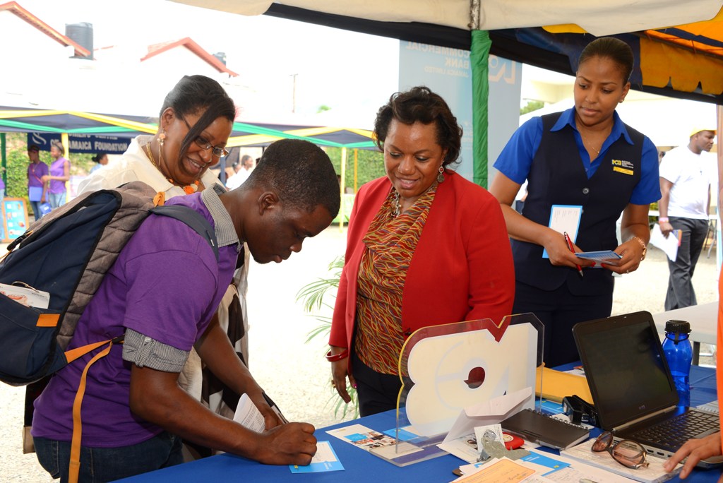 Medical Student Mackoy McNeish gets information on NCB services, as CEO of the CDA Rosalee Gage-Grey (second right); CDA Finance Director (left) and the NCB representative looks on. 