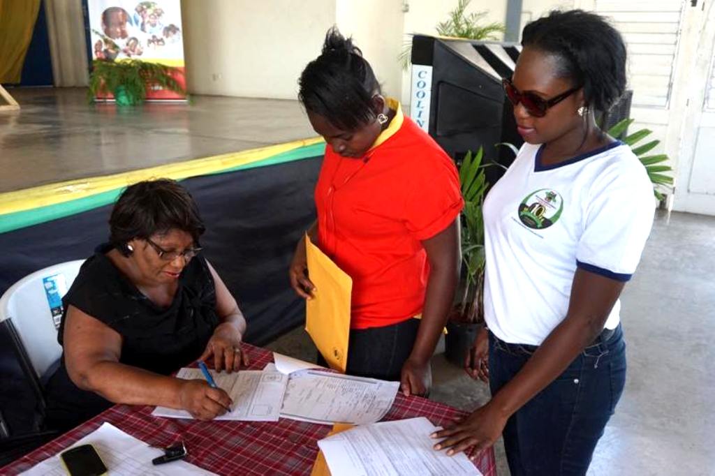 CDA’s Director of Children and Family Programmes, Ms. Audrey Budhi (seated left) signs a document for a child in State care (centre) at the CDA’s career and information expo, held recently at the Girls Guide Headquarters on Wednesday (March 11). Observing the signing is CDA’s Children’s Officer in the North East Region, Sharline Alcindor (right).